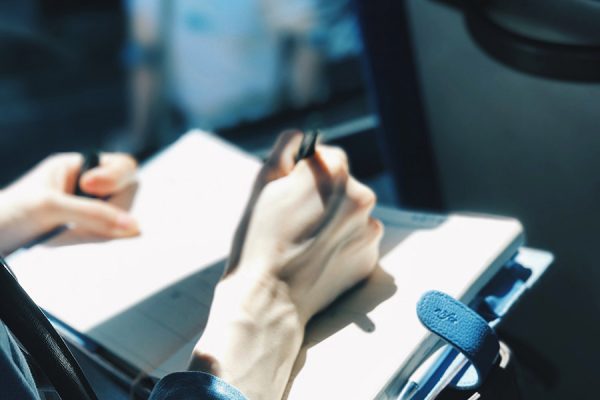 Close-up of a person making notes in a journal/scheduler.