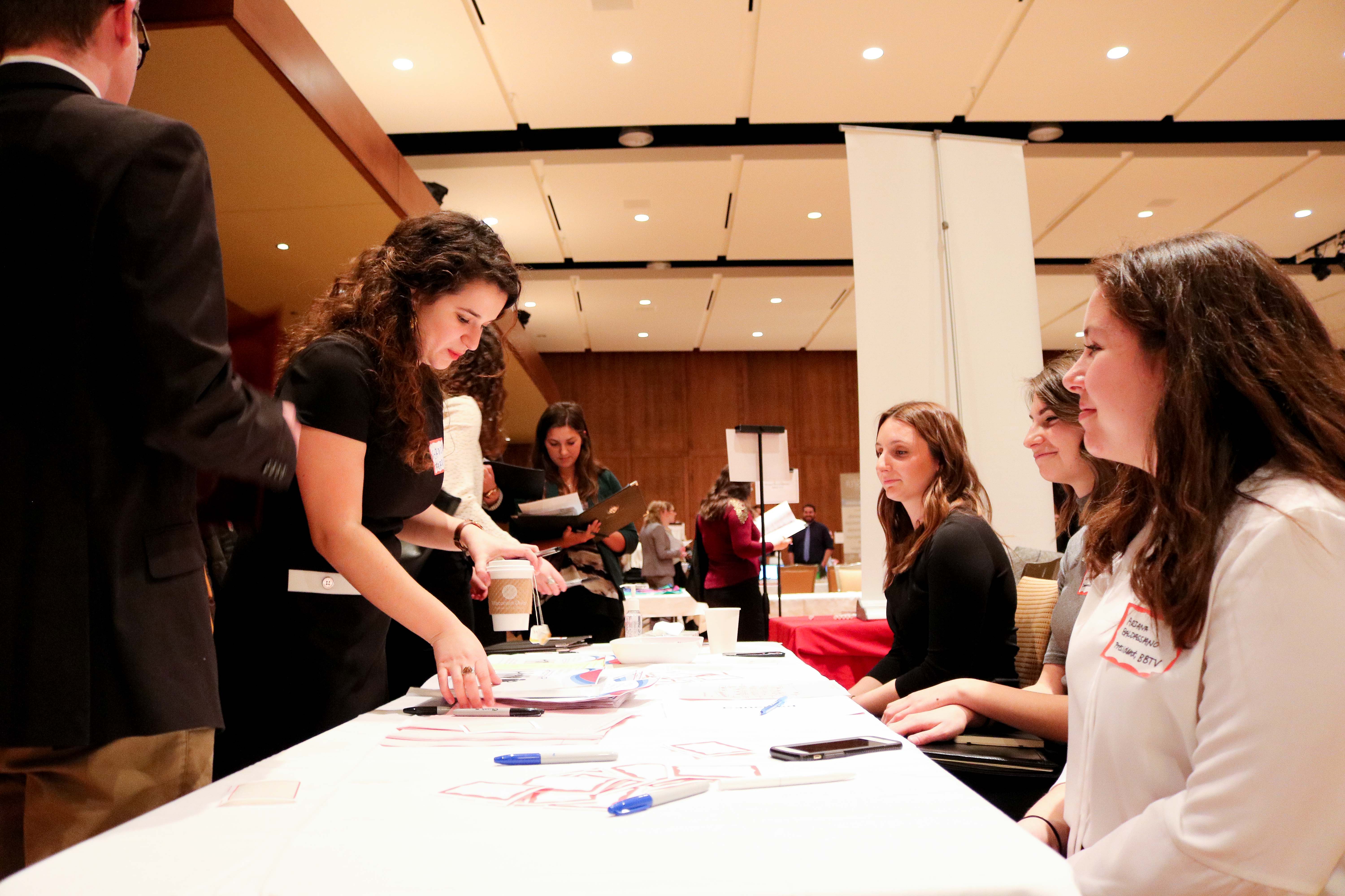 A student visits a table at the advertising and communications career fair.