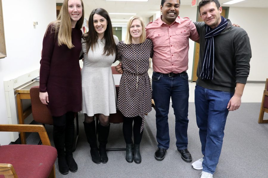 Faculty associate Stacy Forster with two male and two female students graduating from the Professional MA program