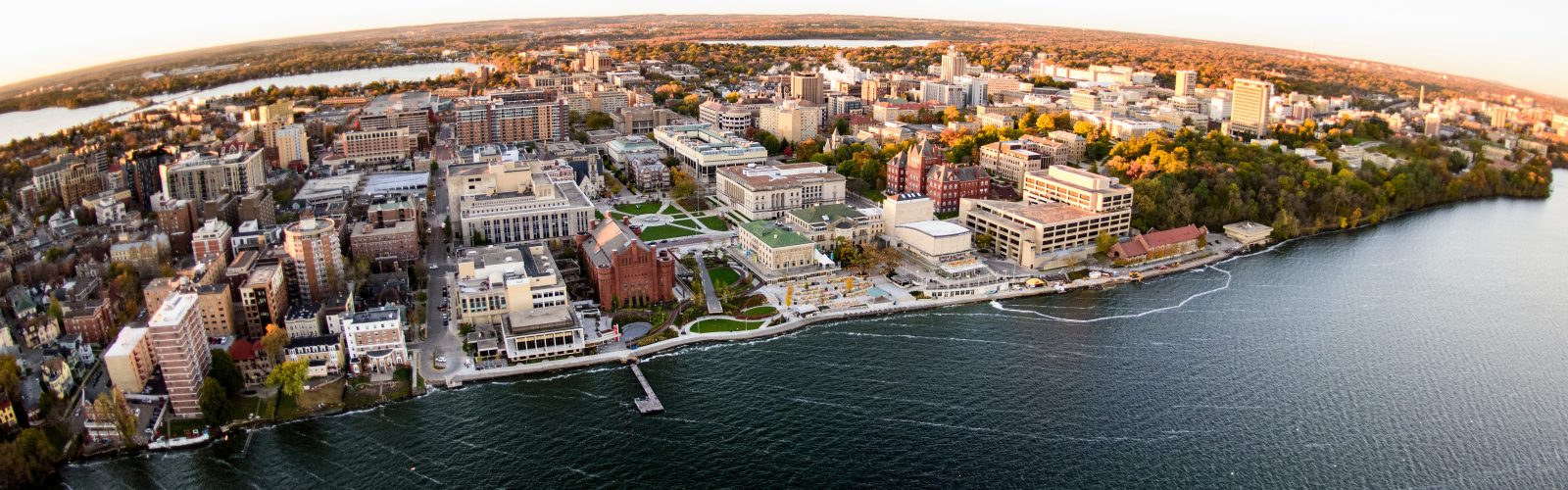 Lake Mendota and the University of Wisconsin-Madison campus, including the Memorial Union Terrace, are pictured in an early morning aerial taken from a helicopter on Oct. 23, 2018. This photograph was captured with a fisheye lens. (Photo by Bryce Richter /UW-Madison)