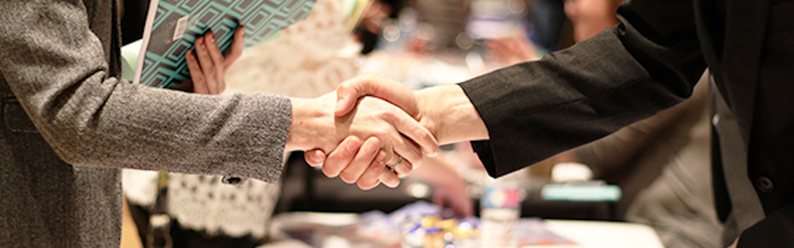 Two people shaking hands at a career fair