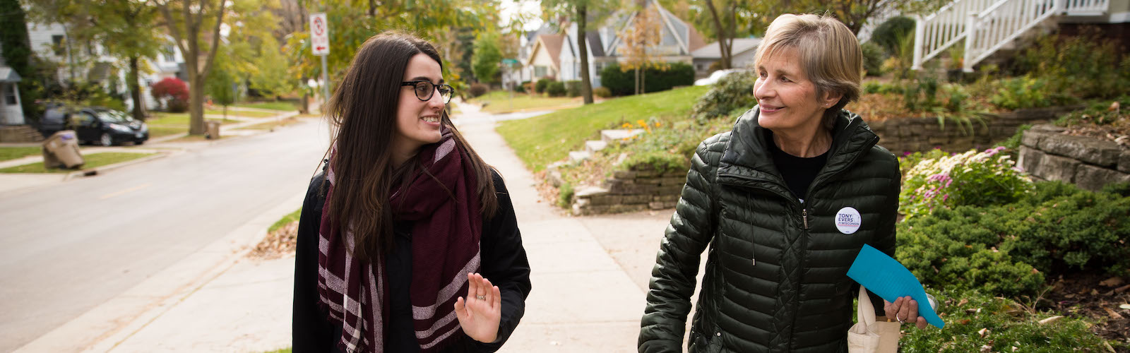 Two women walking and talking outdoors. Pro-track student Cathleen Draper interviews a source for a story for the J-School’s Curb magazine.