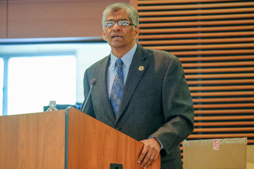 Hemant Shah at a podium at the 2019 SJMC graduation celebration