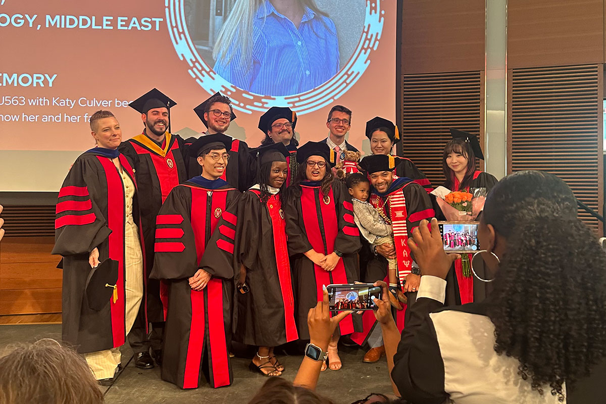 2024 PhD graduates pose together at graduation