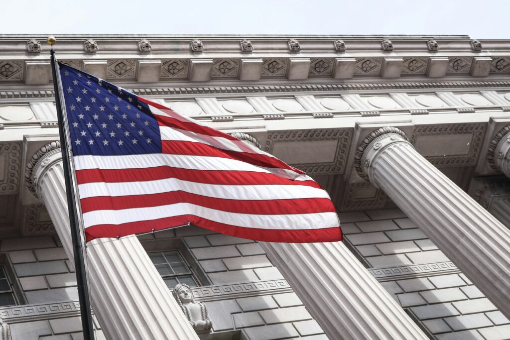 American flag waving in front of a government building.