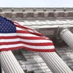 American flag waving in front of a government building.