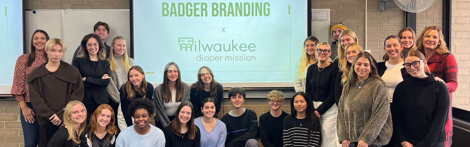 Students pose in the front of the classroom