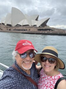 Michael Aguilar and his wife pose for a selfie across the harbor from the Sydney Opera House.