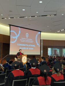 Director Katy Culver addresses an auditorium of graduates.