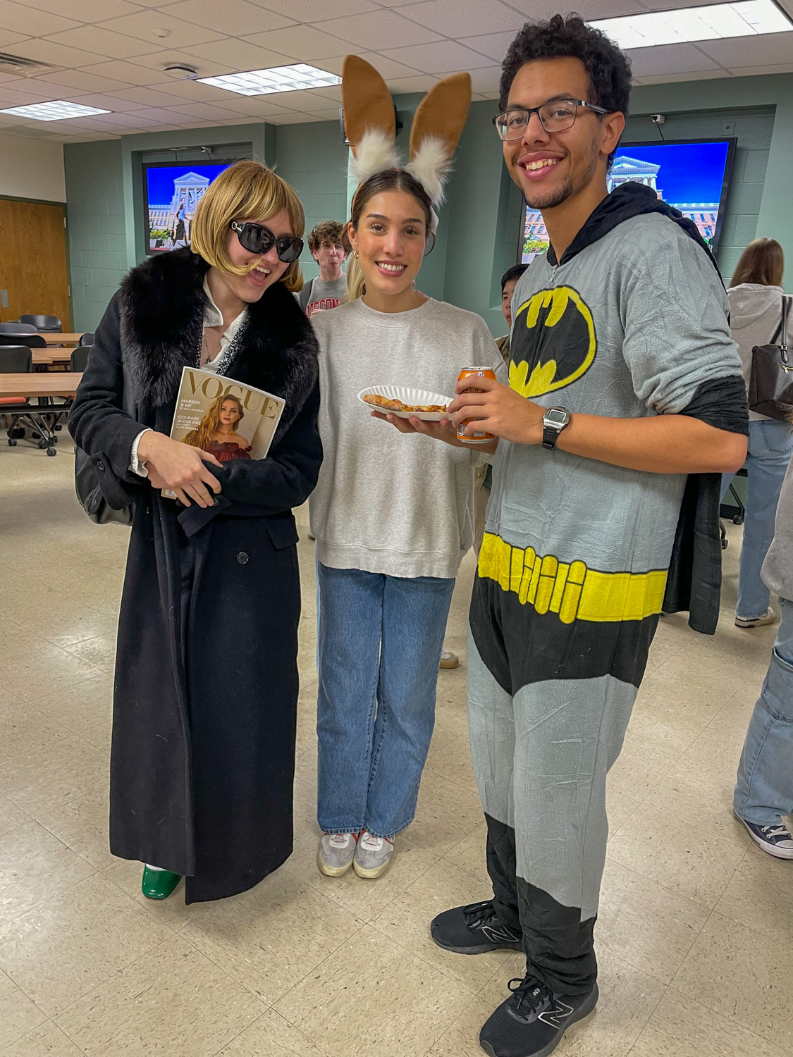 Three students in Halloween costumes pose together.