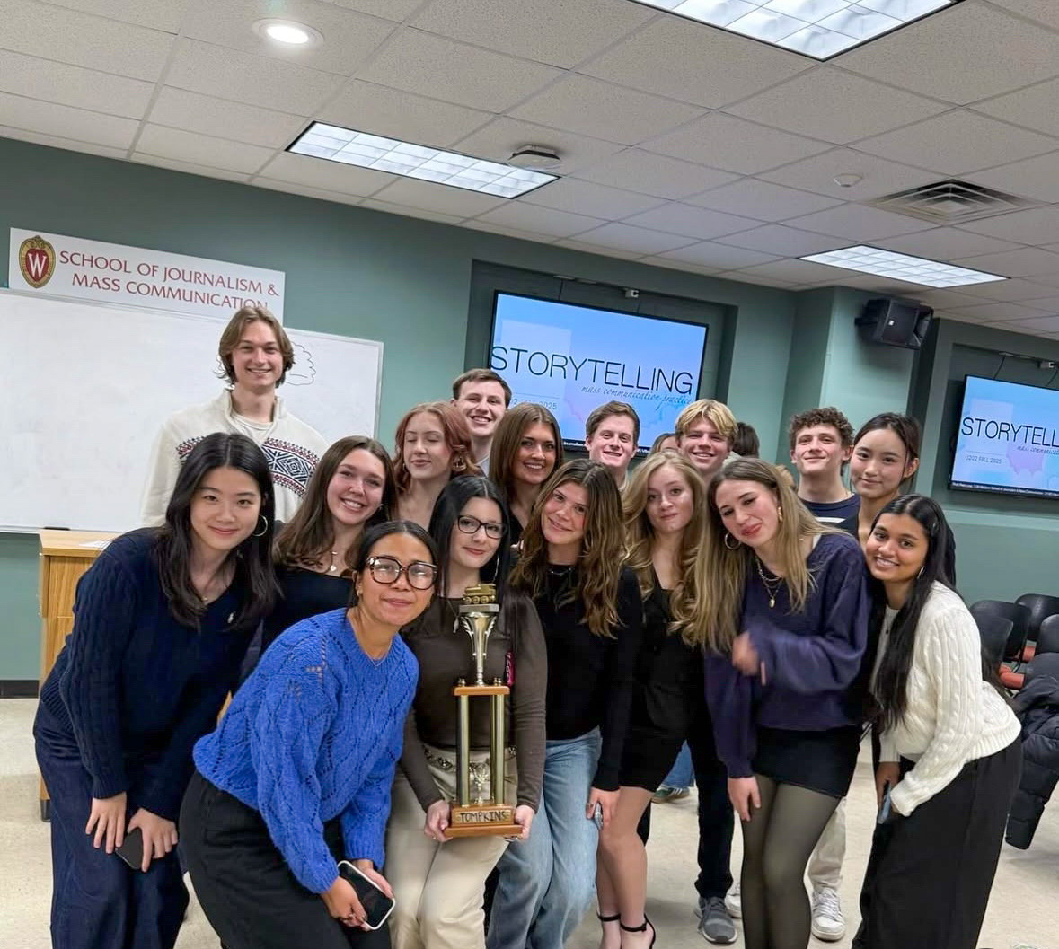A group of students pose with a large trophy