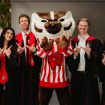A group of graduates pose with Bucky Badger