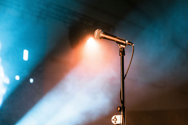 A microphone on a stand with lights shining up at it