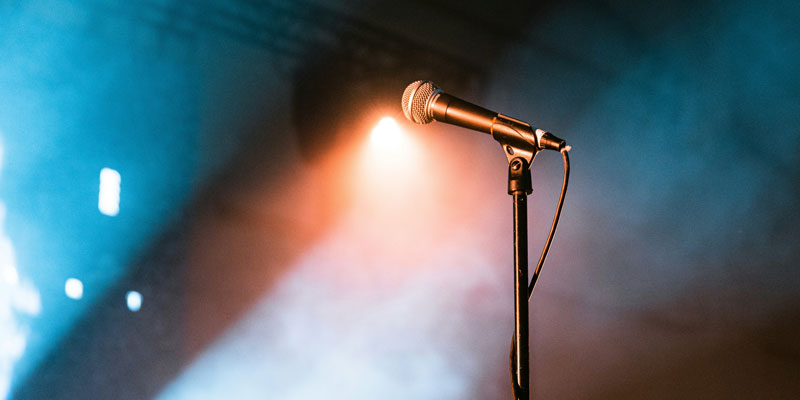 A microphone on a stand with lights shining up at it