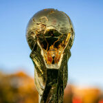 The top of the FIFA World Cup trophy with the blue sky in the background